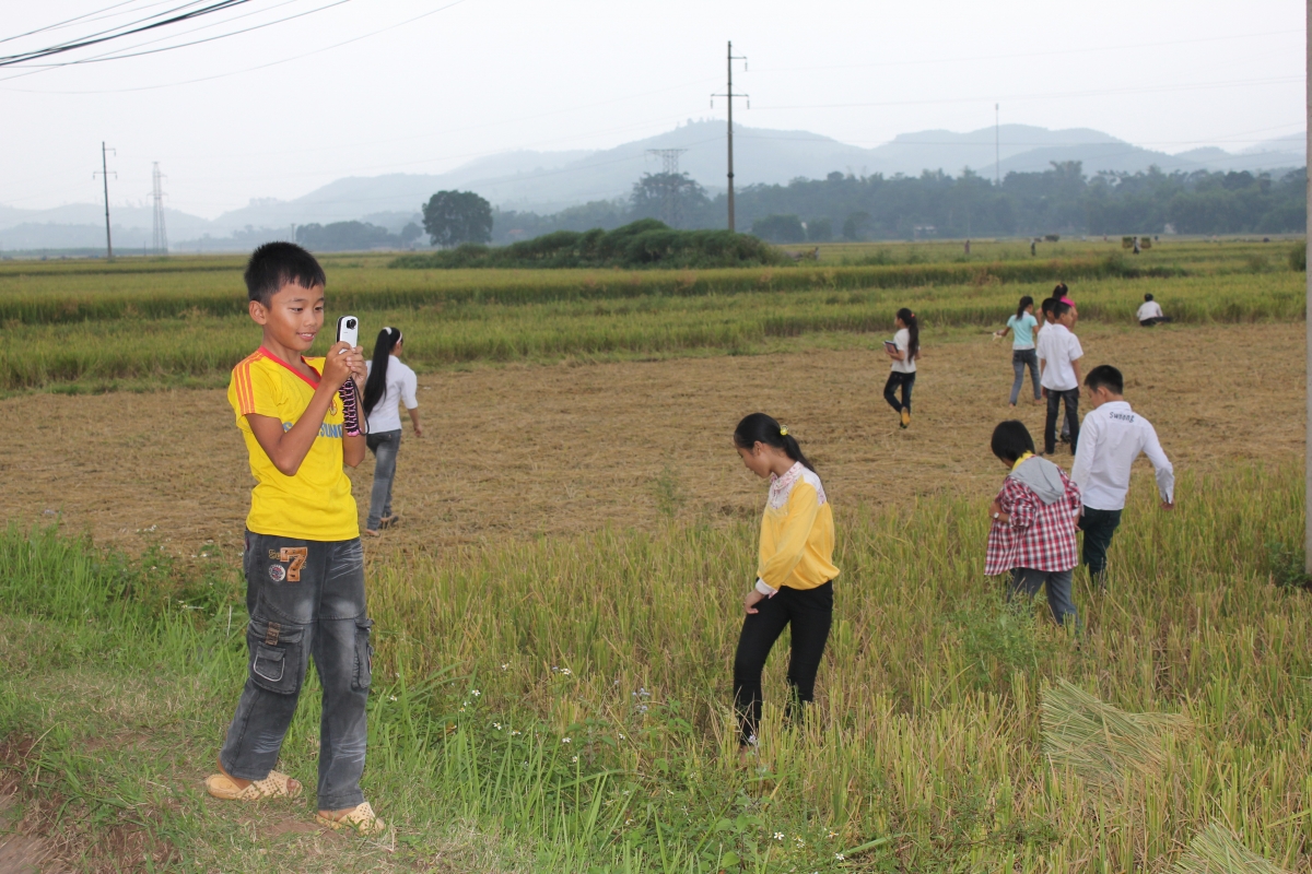 Children practice film making in the rice fields