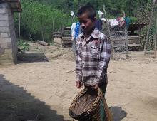 A boy holds a basket. 